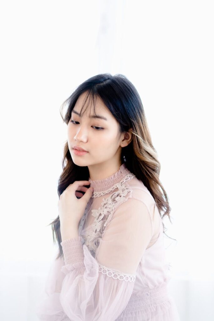 Elegant portrait of a young woman in a delicate lace dress, exuding calm and contemplation.